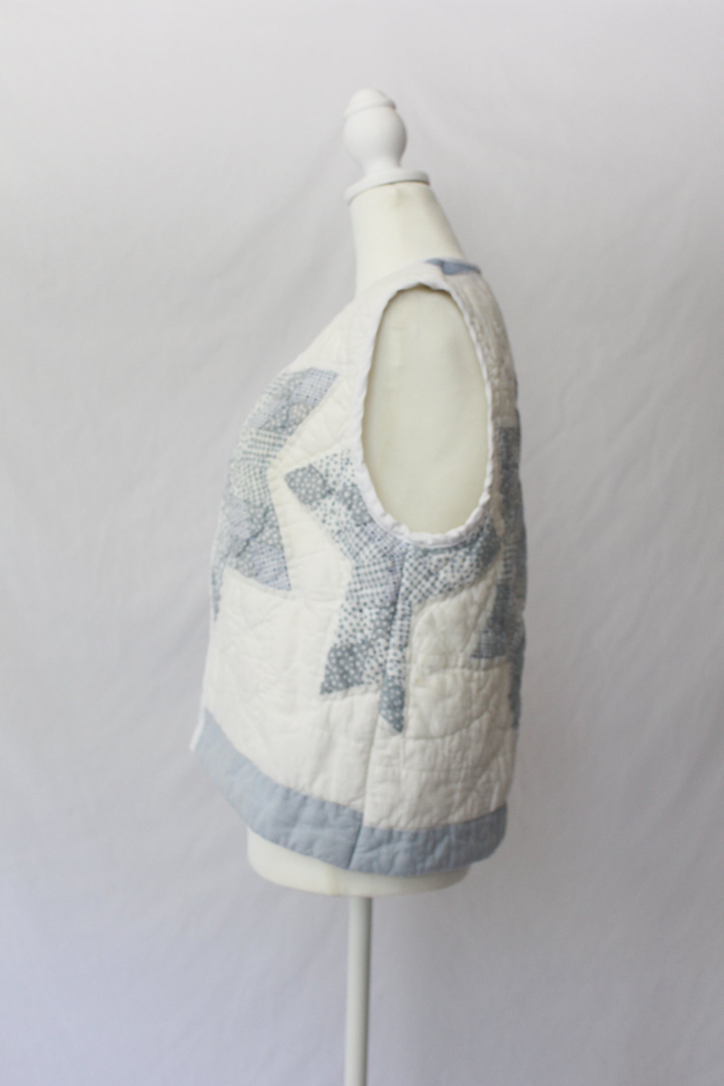 side of white and blue quilt vest with star