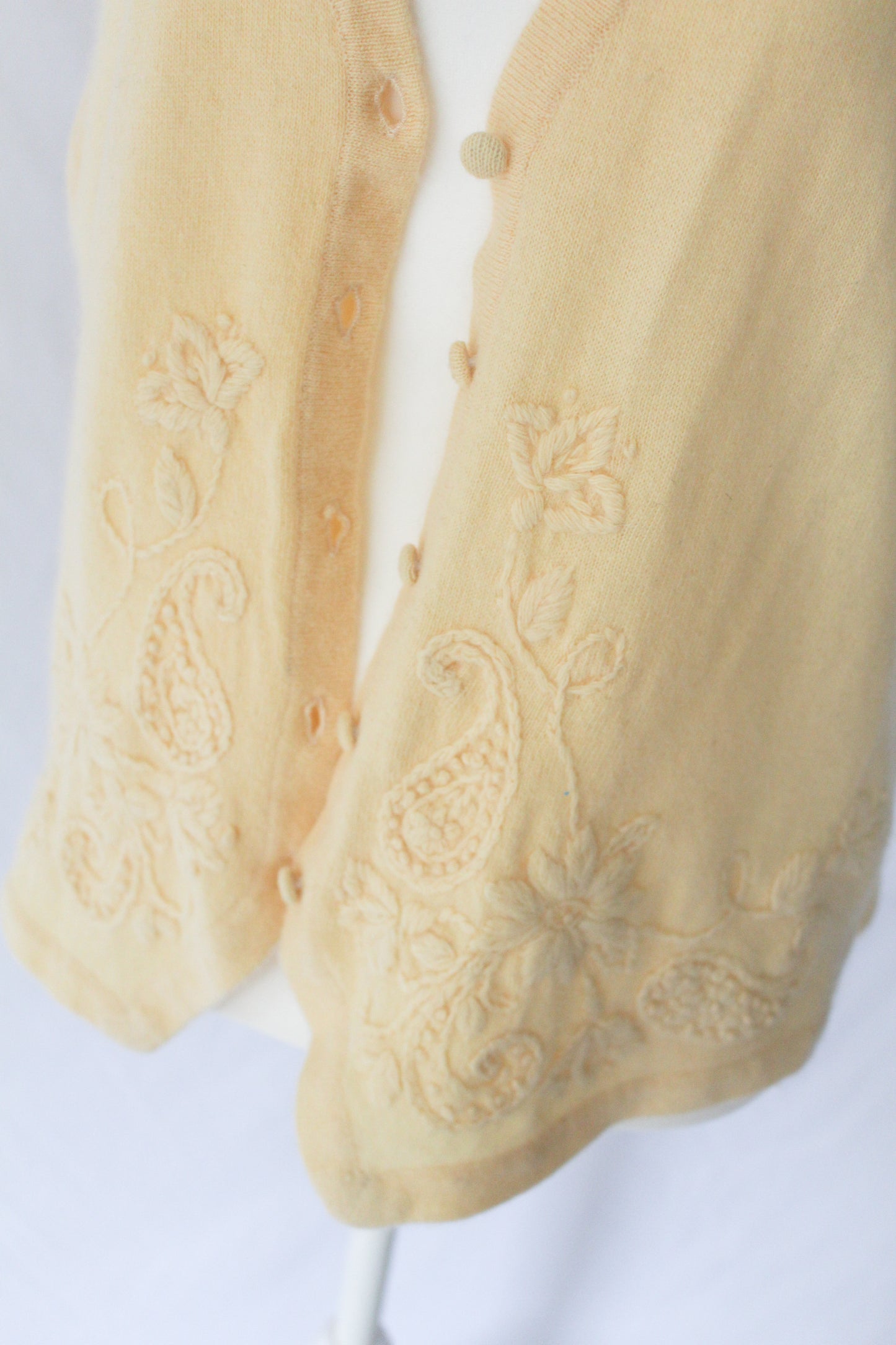 embroidery detail on light yellow knit vest
